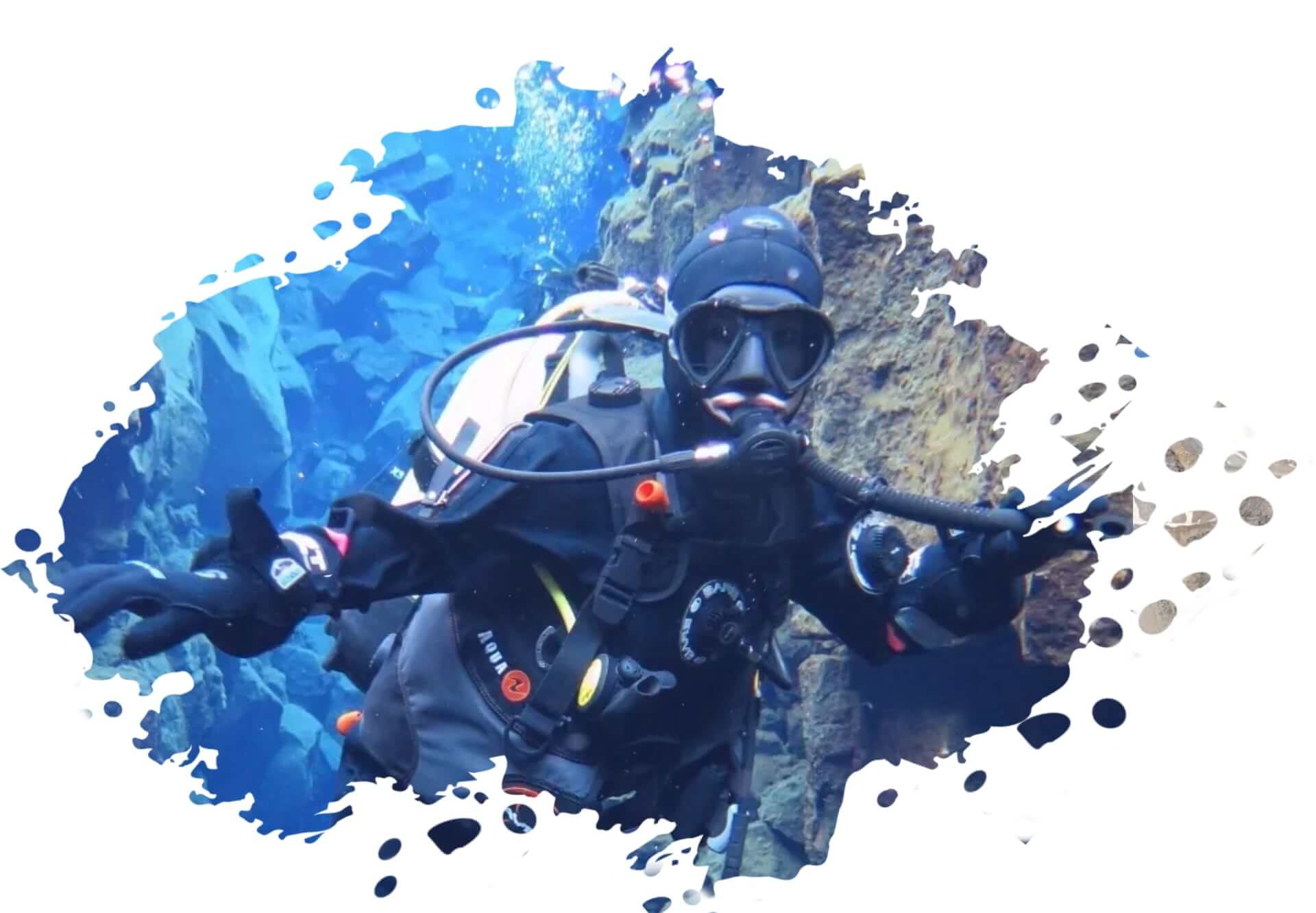 Scuba diver underwater near rocky crevice